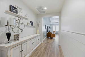 Corridor with light wood-style floors and recessed lighting