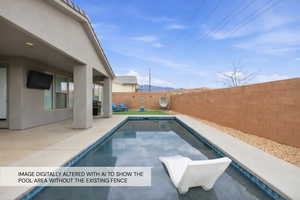 View of swimming pool featuring patio surround and a fenced backyard