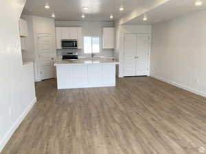 Kitchen featuring white cabinetry, light countertops, a kitchen island, recessed lighting, and stainless steel appliances