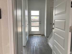 Doorway with wood finished floors and baseboards