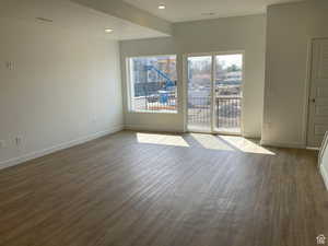 Empty room featuring dark wood finished floors and recessed lighting