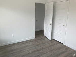 Unfurnished bedroom with dark wood finished floors and a closet