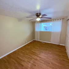 Unfurnished room featuring a textured ceiling, light wood-style flooring, and ceiling fan