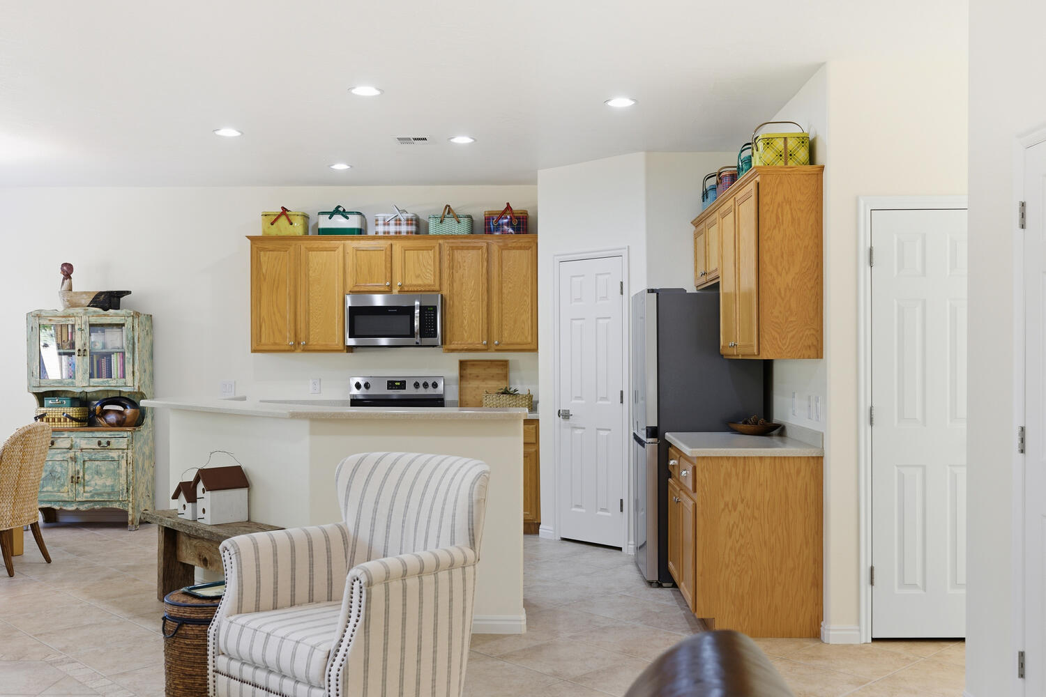 Kitchen with light countertops, stainless steel appliances, wood finish cabinetry, recessed lighting, and light tile patterned floors