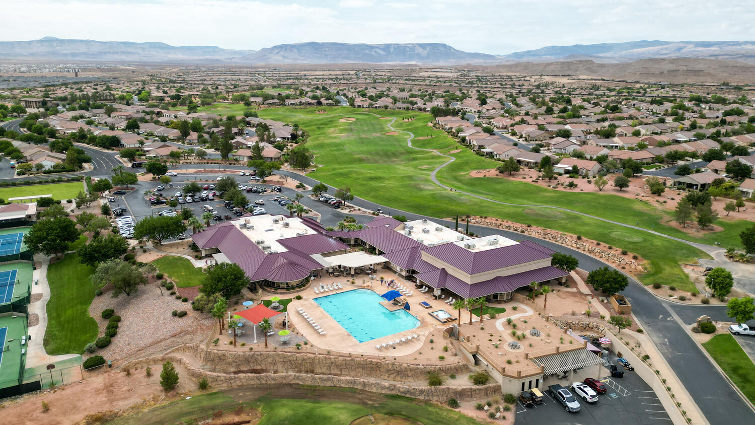 Aerial overview of property's location featuring a golf course and nearby suburban area
