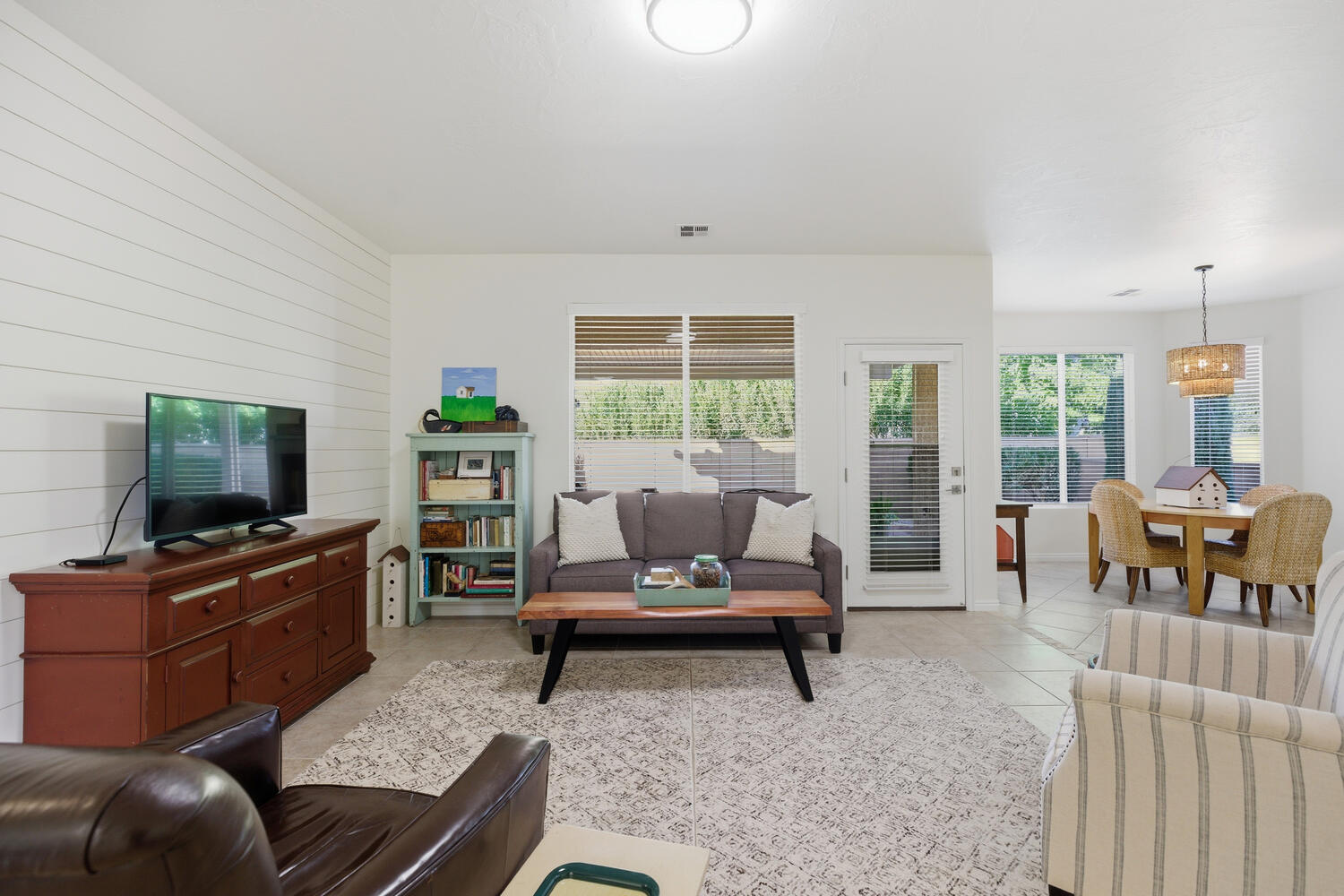Living area with light tile patterned floors and wood walls