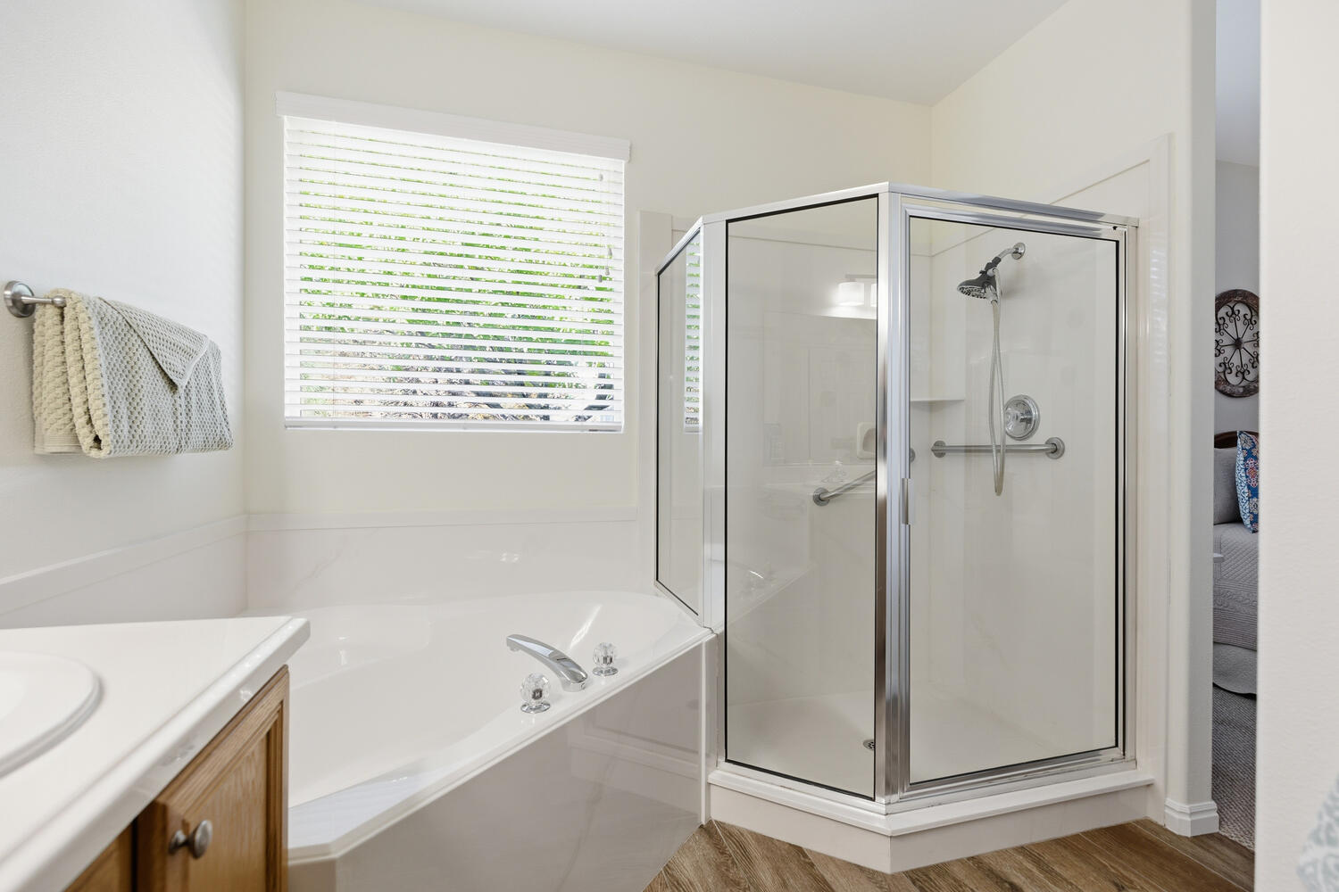 Full bathroom with vanity, a shower stall, a garden tub, and light wood-type flooring