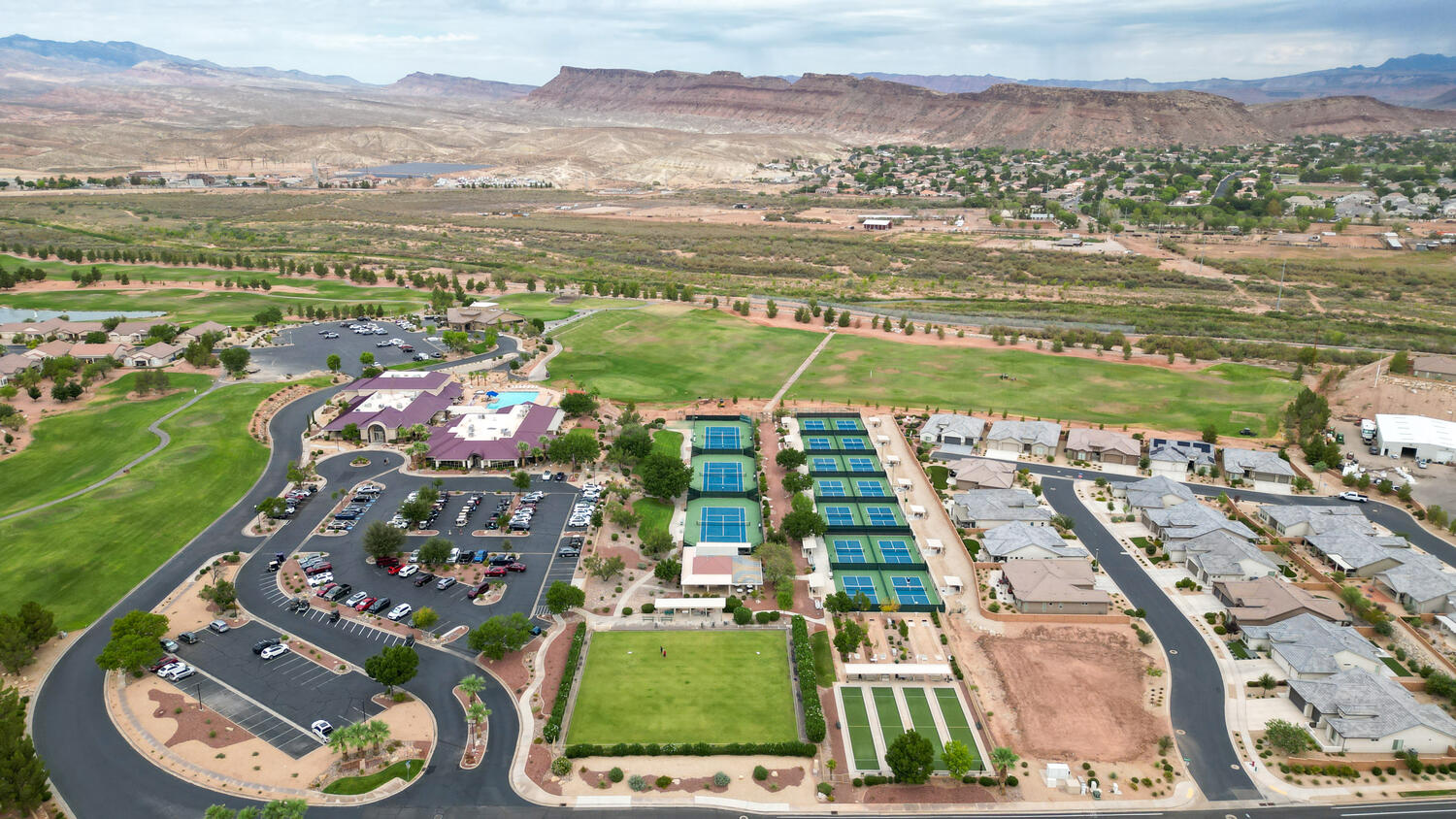Aerial view of residential area featuring a local golf course and mountains