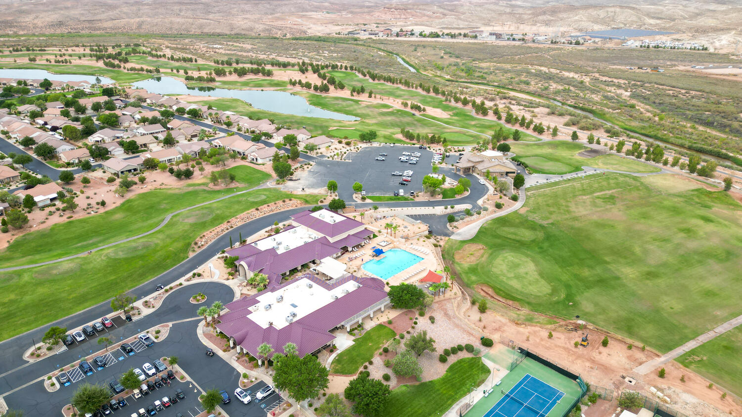 Aerial view of property and surrounding area with a golf club and a large body of water