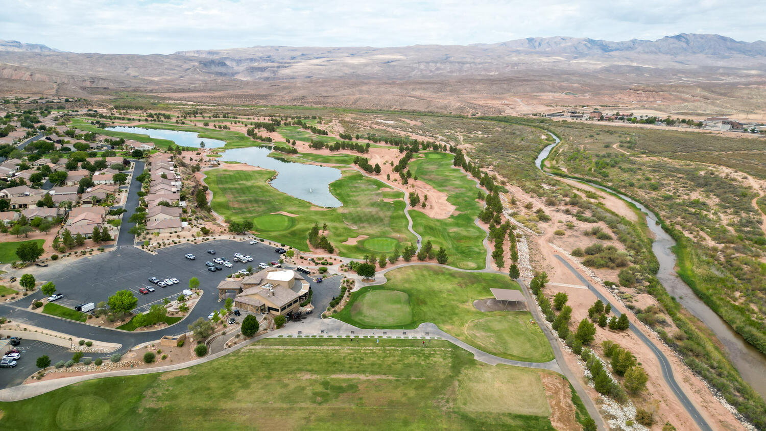 Aerial overview of property's location featuring a golf club, a water and mountain view, and nearby suburban area