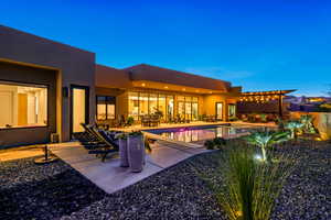 Pool at dusk with a patio area and outdoor dining space