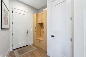 Mudroom with light wood-style floors and baseboards