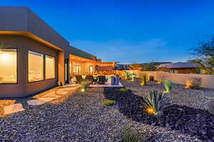 Yard at dusk featuring a fenced backyard, a patio, and an outdoor lounge area