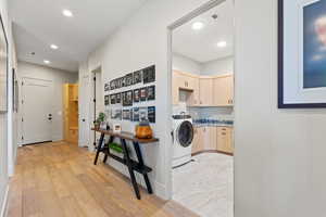Laundry area featuring cabinet space, washer / dryer, recessed lighting, and light wood-style flooring