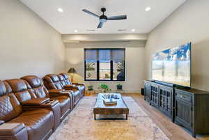 Living area with a ceiling fan, light wood-style floors, and recessed lighting