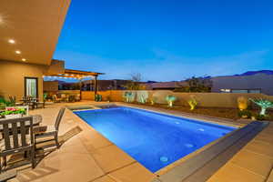 View of swimming pool with patio surround, a fenced backyard, and outdoor dining space