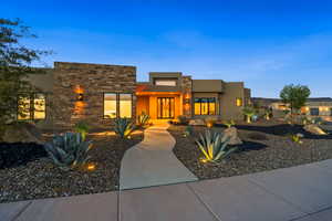 View of front of home featuring stone siding and stucco siding