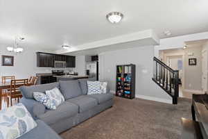 Living area with suspended lighting and carpet floors
