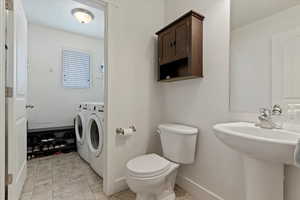 Bathroom featuring separate washer and dryer and toilet