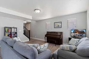 Living area featuring carpet and stairs