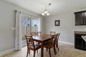 Dining space with baseboards and hanging lights