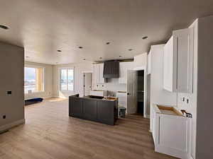 Kitchen featuring a kitchen island, two tone cabinets, light wood finished floors, and recessed lighting