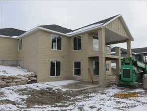 Back of home NW  side of home with a patio & deck area and  siding