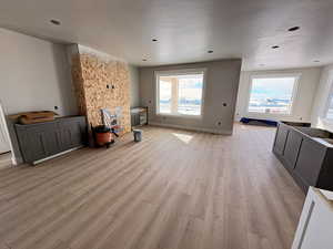 Unfurnished living room with light wood-type flooring and baseboards