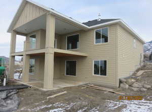 Back of home SW view of home and deck featuring a patio, a balcony, and board and batten siding