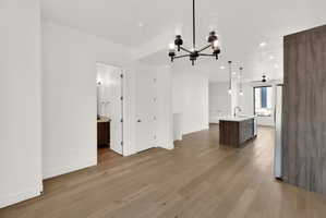 Unfurnished dining area featuring light wood-type flooring and suspended lighting