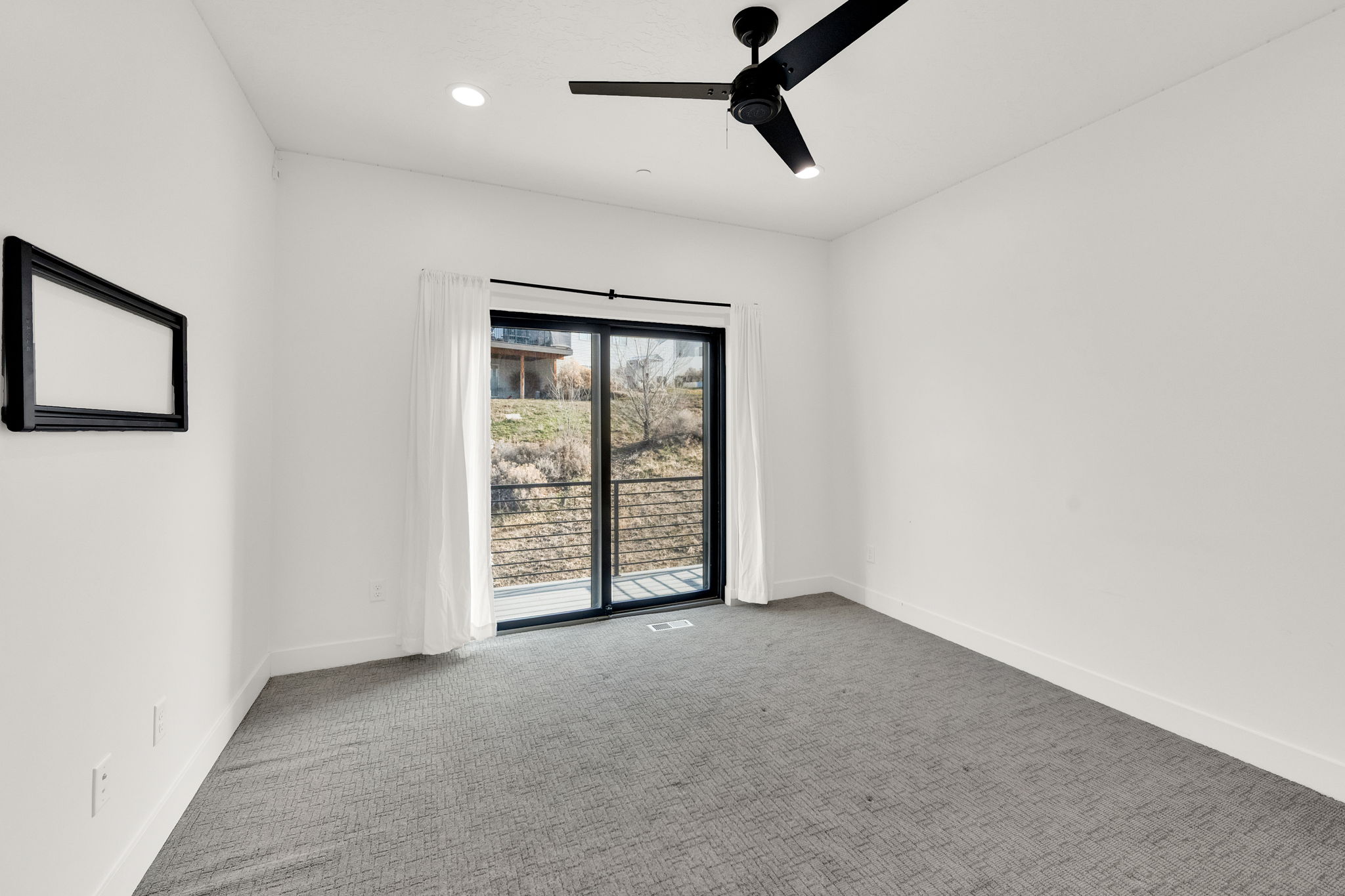 Carpeted empty room featuring ceiling fan and recessed lighting