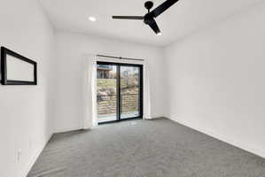 Carpeted empty room featuring ceiling fan and recessed lighting