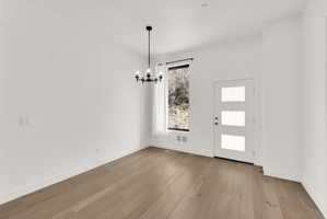Foyer featuring suspended lighting and light wood-style flooring