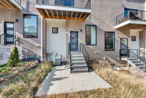 Entrance to property featuring a patio area and brick siding