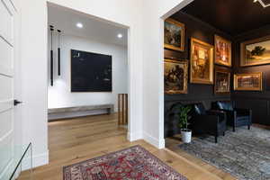 Corridor featuring light wood finished floors, recessed lighting, and crown molding