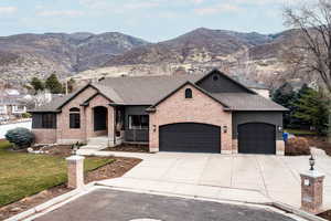 French country home featuring an attached garage, concrete driveway, and a mountain view