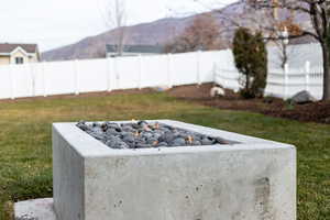 Exterior view of a fenced backyard and a fire pit