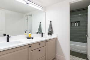 Bathroom featuring double vanity and bathtub / shower combination
