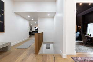 Corridor featuring an office area, light wood-style flooring, and recessed lighting