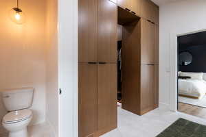 Ensuite bathroom with light tile patterned flooring and toilet