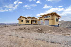 Property in mid-construction featuring stucco siding, driveway, a mountain view, and a garage