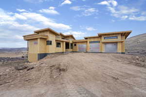 Property under construction featuring driveway, a mountain view, and an attached garage