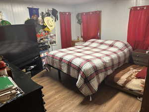 Bedroom with light wood-style flooring and wood walls