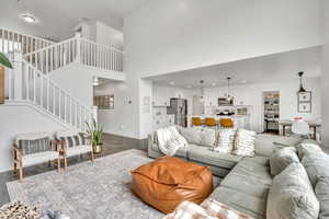 Living area with wood finished floors, a high ceiling, and recessed lighting