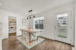Dining room with dark wood-style floors and built in features
