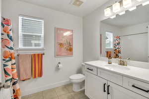 Bathroom with a shower with curtain, vanity, and light tile patterned floors