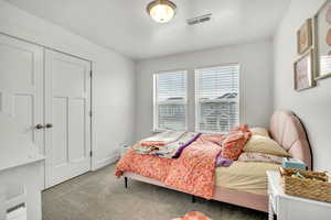 Carpeted bedroom featuring a closet and baseboards