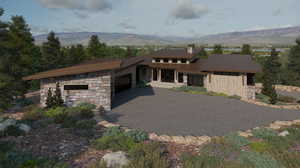 Prairie-style house featuring stone siding, a mountain view, a garage, asphalt driveway, and a metal roof