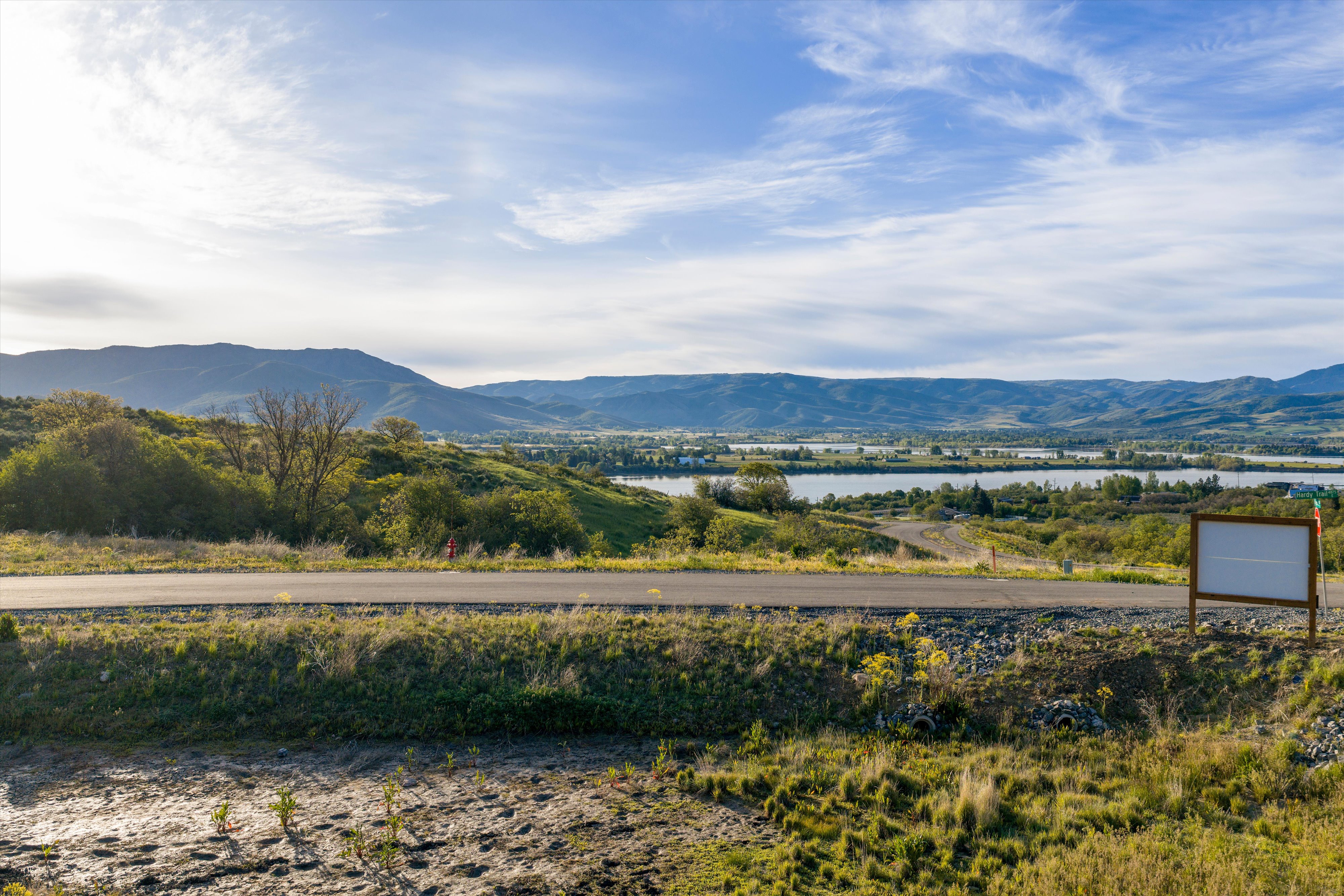 Expansive land parcel featuring distant mountain ranges and multiple bodies of water
