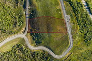 Expansive land parcel featuring natural topography, established road frontage, and surrounding green spaces